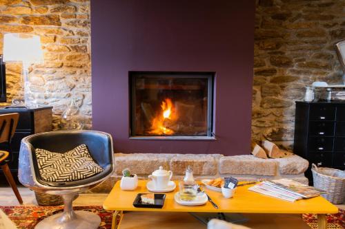 グロワにあるTy Mad Hôtelのリビングルーム(暖炉、テーブル、椅子付)