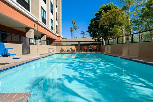 a swimming pool at a hotel with a building at Holiday Inn Express Los Angeles LAX Airport, an IHG Hotel in Los Angeles