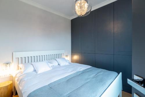 a bedroom with a large bed with blue walls at Apartamenty Bazyliańska 1 lok 4 in Zamość