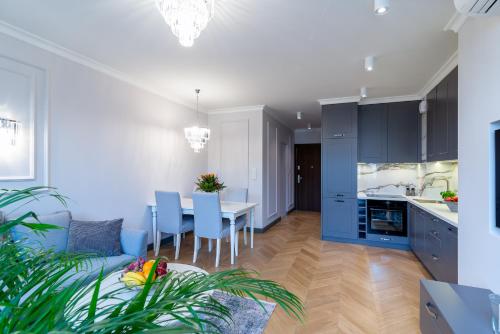 a kitchen and dining room with a table and blue cabinets at Apartamenty Bazyliańska 1 lok 4 in Zamość