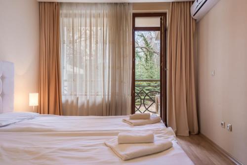 1 dormitorio con 1 cama con 2 toallas en Golden Sands Rentals Apartments, en Golden Sands
