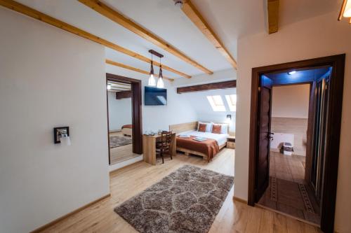 uma sala de estar com um quarto e uma cama em Cabana Parang em Ranca