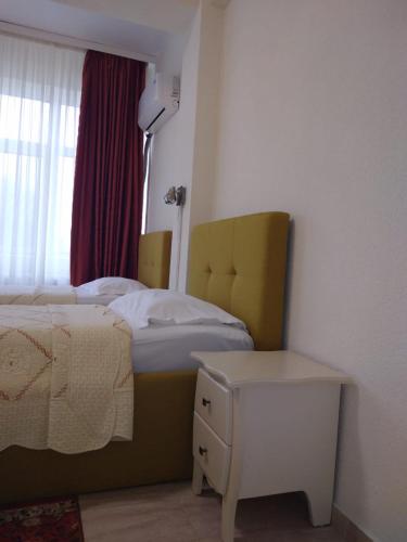 a bedroom with a bed and a table and a window at Hotel Florentina in Constanţa