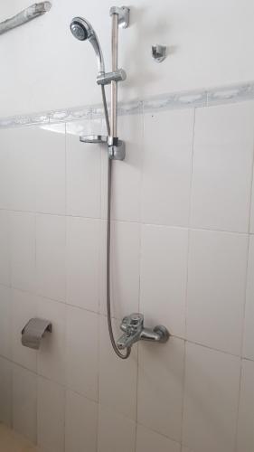 a shower in a white tiled bathroom at Mount View Inn in Kandy