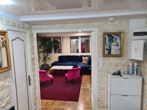 - un salon avec un canapé bleu et des chaises roses dans l'établissement Luxueux Appartement, 350m métro Castellane, à Marseille