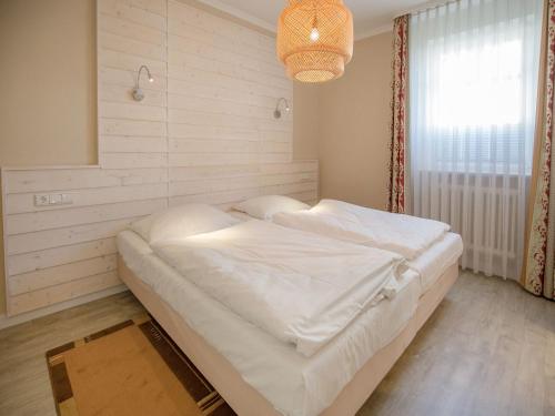 1 dormitorio con 1 cama blanca grande en una habitación en Dünenpark Binz - Komfortplus Ferienwohnung mit 1 Schlafzimmer und Terrasse im Erdgeschoss 213, en Binz