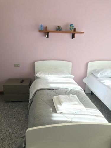 een slaapkamer met 2 bedden en een plank aan de muur bij Camera con bagno Mirjana in Cislago
