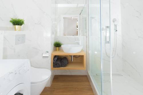 y baño con aseo, lavabo y ducha. en Maloves Apartment NETFLIX, en Łódź