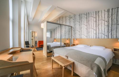 a bedroom with a large bed and a mirror at Jugend Boutique Hotel in Pietarsaari