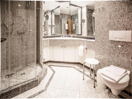 ein Bad mit einer Dusche, einem WC und einem Waschbecken in der Unterkunft Dünenpark Binz - Komfort Ferienwohnung mit 1 Schlafzimmer und Balkon im Dachgeschoss 234 in Binz