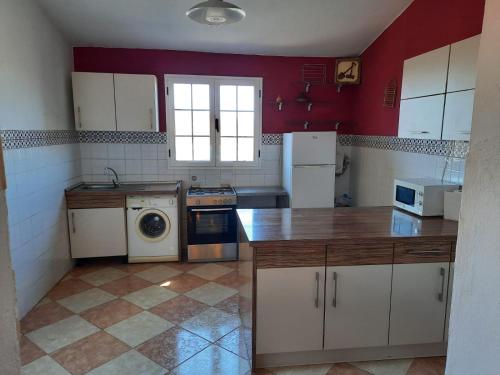 uma cozinha com electrodomésticos brancos e paredes vermelhas em Casa rural,Naturaleza,Vacaciones em Teguitar