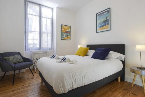 une chambre avec un grand lit et une chaise dans l'établissement Appartement Sereno - Welkeys, à Biarritz