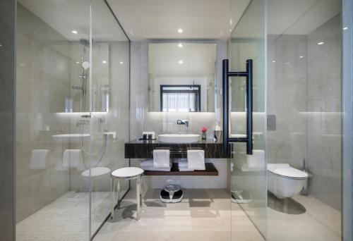a bathroom with a shower and a sink and a toilet at Hotel Ambasador - Liburnia in Opatija