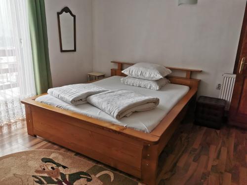 a bed with four pillows on it in a room at Pensiunea Bradet - Padis in Padis