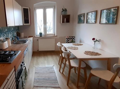 eine Küche mit einem Tisch und Stühlen sowie eine Küche mit einem Waschbecken in der Unterkunft Lemuria Hostel Szkolna centrum in Legnica