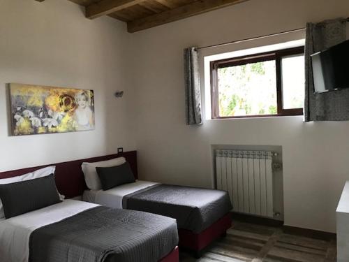 a room with two beds and a window at Agriturismo Ali E Radici in Cisterna di Latina