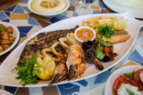 a plate of food with seafood and vegetables on a table at InterContinental Aqaba by IHG in Aqaba
