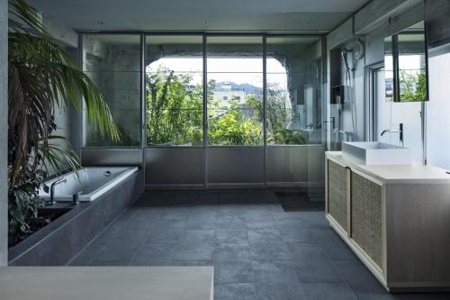 a bathroom with a tub and a sink at hotel sou #sou in Goto