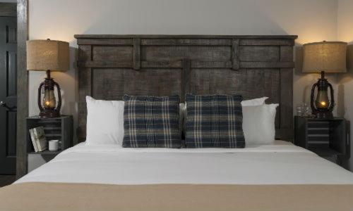 a bedroom with a large white bed with two lamps at Lake Bomoseen Lodge in Bomoseen