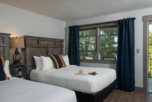 ein Hotelzimmer mit 2 Betten und einem Fenster in der Unterkunft Lake Bomoseen Lodge in Bomoseen
