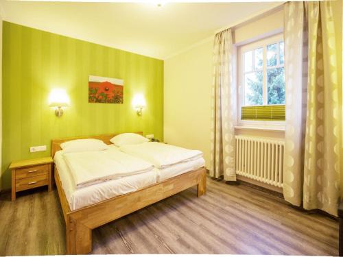 奧茨巴德賓茲的住宿－Dünenpark Binz - Komfortplus Ferienwohnung mit 1 Schlafzimmer und Balkon im Obergeschoss 256，绿色卧室设有床和窗户