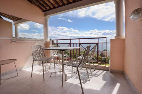 un balcon avec une table et des chaises et une vue dans l'établissement La Perle de Théoule - Welkeys, à Cannes
