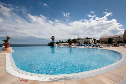 une grande piscine avec des chaises et un ciel bleu dans l'établissement La Perle de Théoule - Welkeys, à Cannes