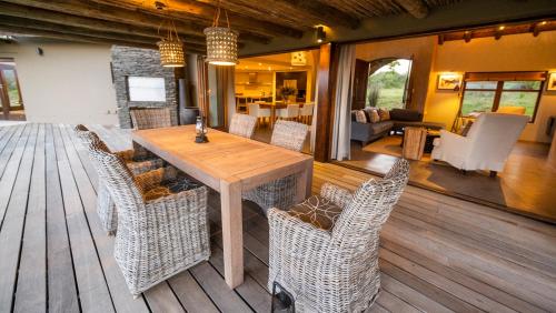 a dining room with a table and chairs on a deck at Gondwana Game Reserve in Kleinberg