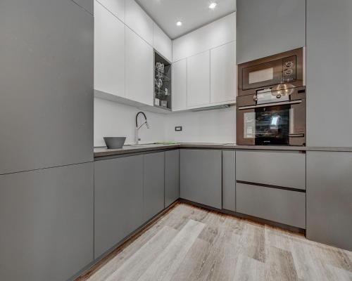 a kitchen with white cabinets and stainless steel appliances at Villa Una in Kotor