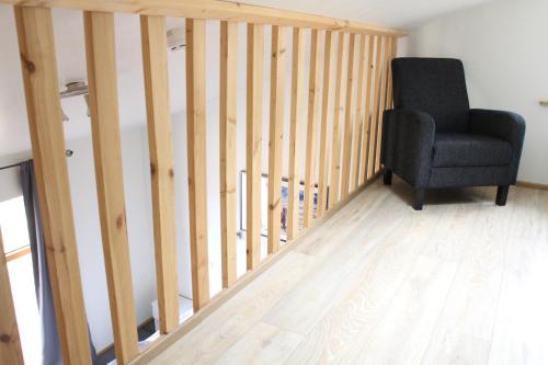 a room with a chair and a wooden staircase at Hótel Á in Reykholt