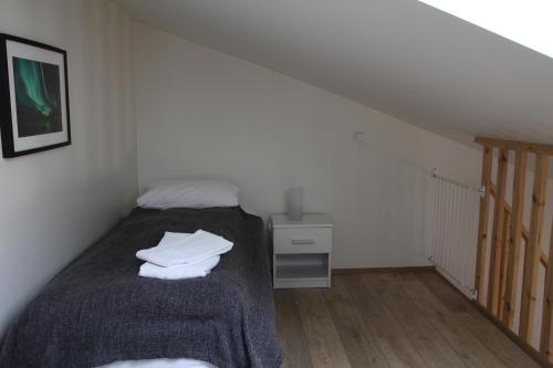 a bedroom with a bed with a blanket and a table at Hótel Á in Reykholt