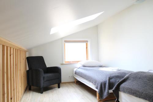 a bedroom with a bed and a chair at Hótel Á in Reykholt