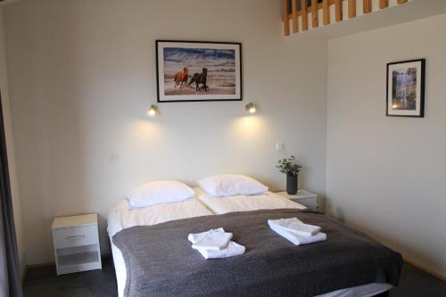 a bedroom with a bed with two towels on it at Hótel Á in Reykholt
