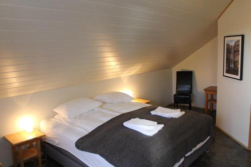 a bedroom with a bed with two towels on it at Hótel Á in Reykholt