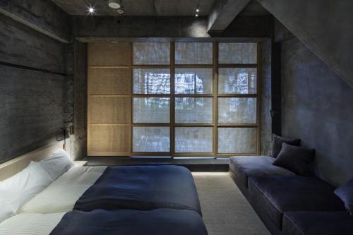 a bedroom with a bed and a couch and a window at hotel sou #sou in Goto