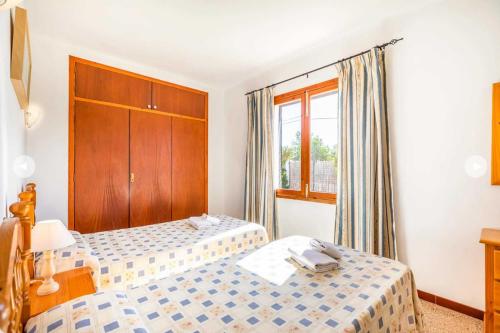 a hotel room with two beds and a window at Villa Margarita in Cala d´Or
