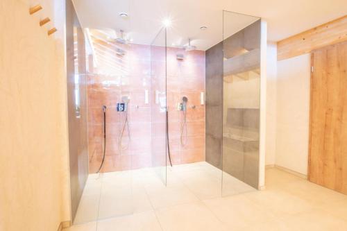 a bathroom with a shower with a glass door at Alpengasthof Hörnlepass in Riezlern