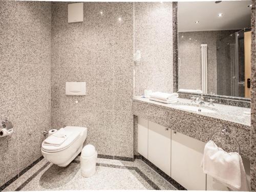 ein Badezimmer mit einem WC, einem Waschbecken und einem Spiegel in der Unterkunft Dünenpark Binz - Klassik Ferienwohnung mit 1 Schlafzimmer und Balkon im Dachgeschoss 271 in Binz