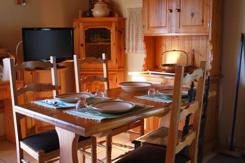- une table en bois avec des assiettes dans la cuisine dans l'établissement Ferme marine pour 4 - Piscine chauffée, à Bretignolles-sur-Mer