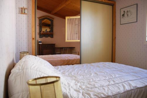 une chambre avec un lit blanc et un miroir dans l'établissement Ferme marine pour 4 - Piscine chauffée, à Bretignolles-sur-Mer