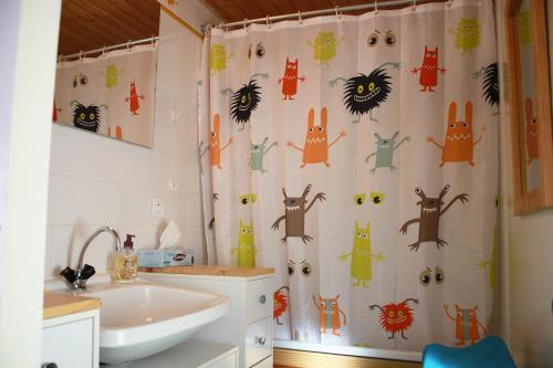 La salle de bains est pourvue d'un rideau de douche avec des chats. dans l'établissement Ferme marine pour 4 - Piscine chauffée, à Bretignolles-sur-Mer