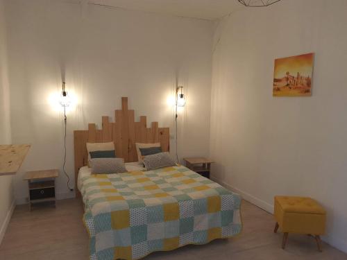 una camera da letto con un grande letto con una coperta a scacchi di L'oasis a Mouleydier