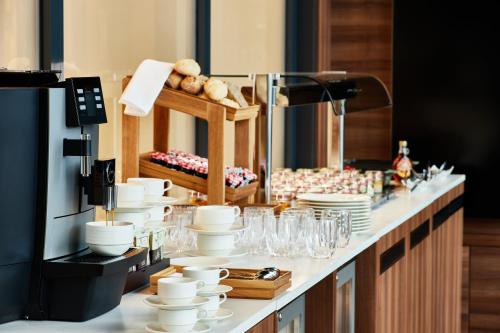 a counter with white cups and plates on it at Crowne Plaza - Warsaw - The HUB by IHG in Warsaw