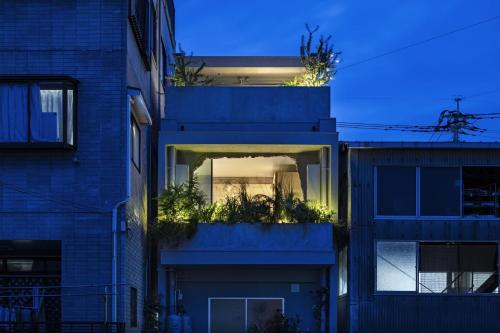 a blue building with plants on the side of it at hotel sou #sou in Goto