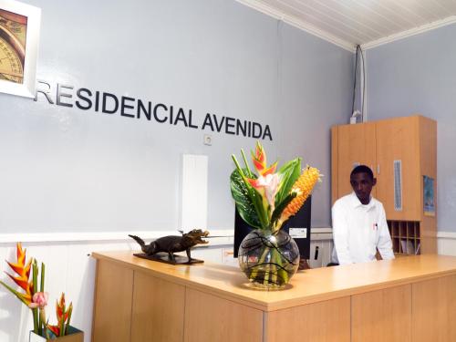 a man standing behind a desk in an office at Hotel Avenida in São Tomé