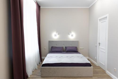 una camera da letto con un grande letto con cuscini viola di Apartment Comfort plus IQ a Gatchina