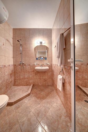 ein Badezimmer mit Dusche, Waschbecken und Toilette in der Unterkunft Aurelia Beach Complex in Rawda