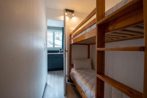 1 dormitorio con 2 literas y ventana en Un appartement coquet au pied des pistes, en Val Louron