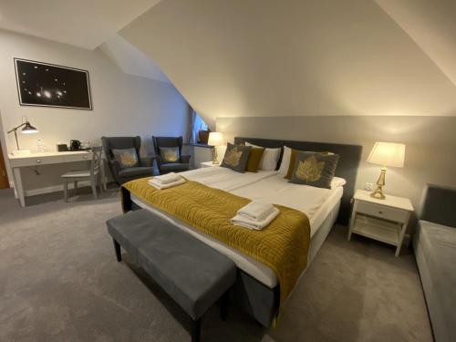 a bedroom with a large bed with a desk and chairs at Pałac Łochów in Łochów