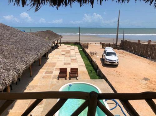 Un coche aparcado junto a una playa con un edificio. en Amar Pousada, en Luís Correia